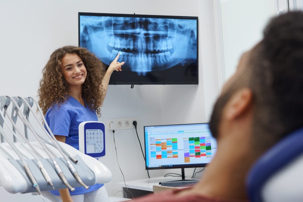 Dentist reviewing an X-ray with a patient for root canal treatment in Waterford