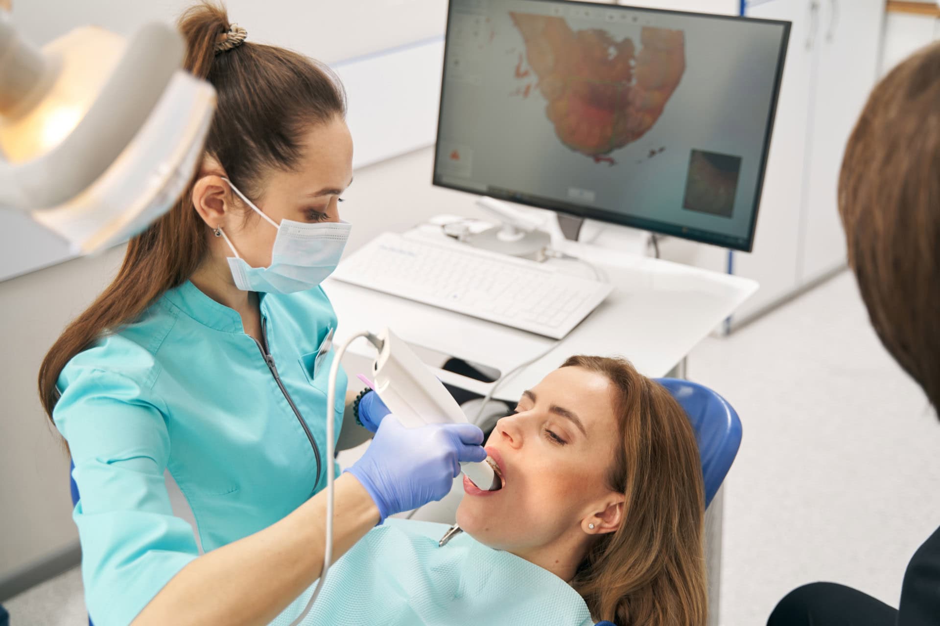 Dentist scanning teeth with interoral camear